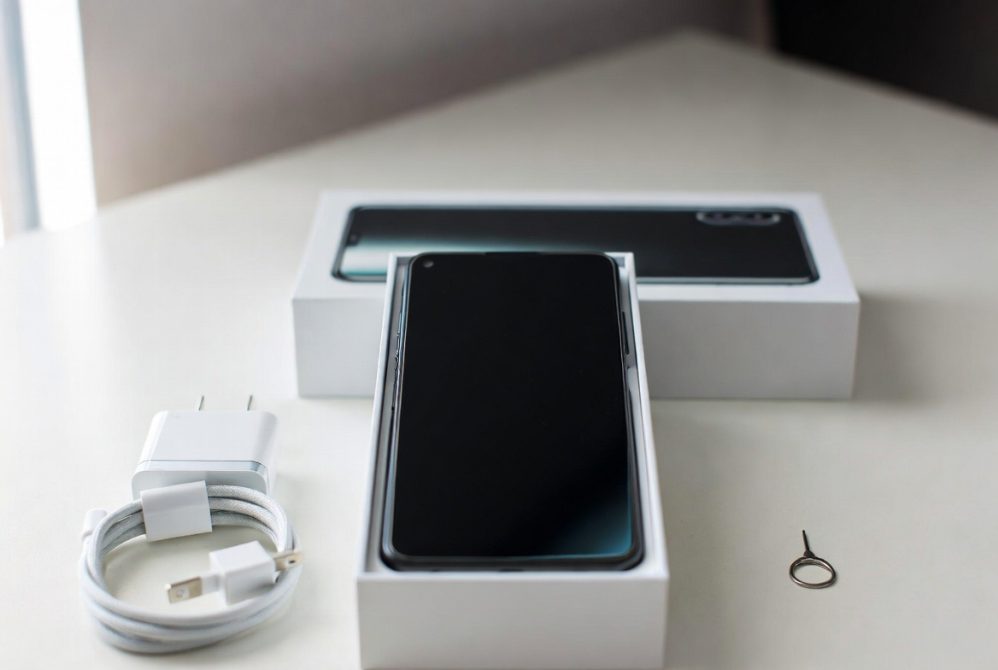 Unboxing a new Android smartphone with accessories like charger and SIM tool